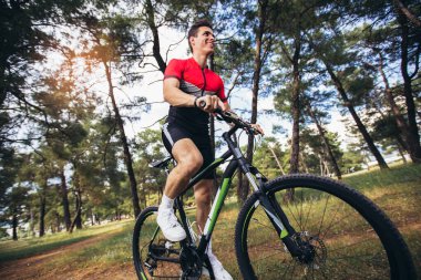 Ormanda bisiklet süren dağ bisikletçisi. Sağlıklı yaşam tarzı ve açık hava macerası..