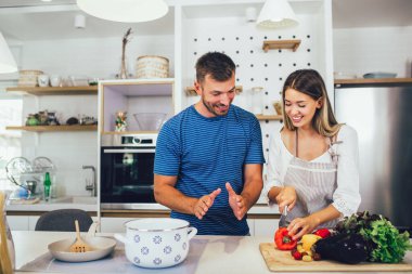 Evde sağlıklı yiyecekler. Mutlu çift mutfakta doğru düzgün bir yemek hazırlıyor..