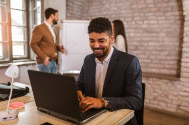 Açık uzay ofisinde dizüstü bilgisayarı olan Afrikalı Amerikalı iş adamı.. 