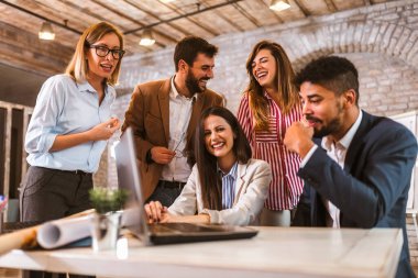 Business team working on new project and smiling. Man and women sitting together in modern office