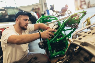 Motosiklet tamir servisinde çalışan profesyonel bir motor tamircisi.