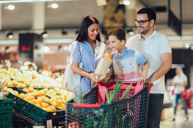 Marketten veya süpermarketten meyve alan mutlu bir aile - alışveriş, yemek, satış, tüketim