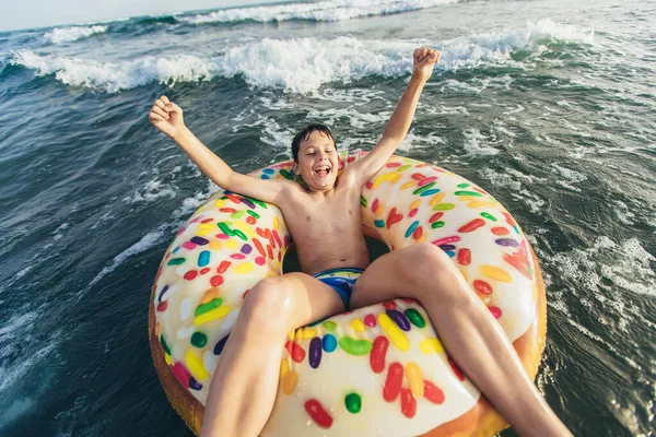 快乐的孩子骑着充气环在破浪前进 旅行生活方式 游泳活动 有选择的重点 — 图库照片