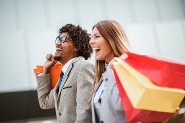 Alışveriş yapan bir çift. Alışveriş torbalı mutlu çift alışverişin tadını çıkarıyor..