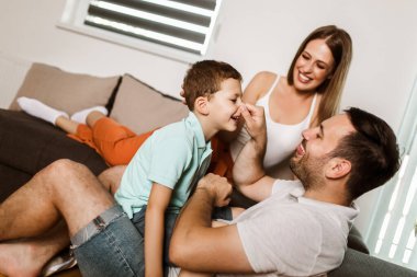 Gündelik evdeki genç ve güzel aile oturma odasındaki rahat halıda yatıyor..