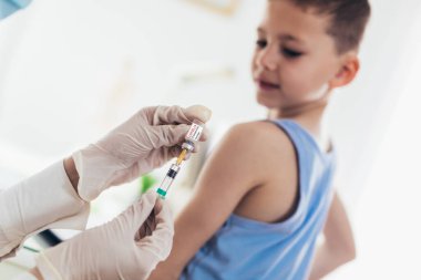 Coronavirus aşısı. Covid-19 aşısı. Çocuk aşılayan doktor. Küçük çocuk grip aşısı oluyor..