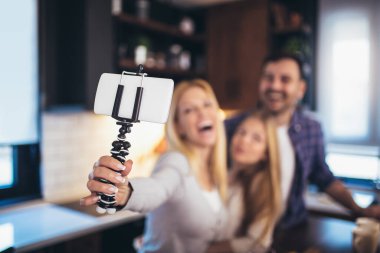 Kız ve güzel ailesi evde yemek pişirirken sebze doğruyor ve gülümsüyor..