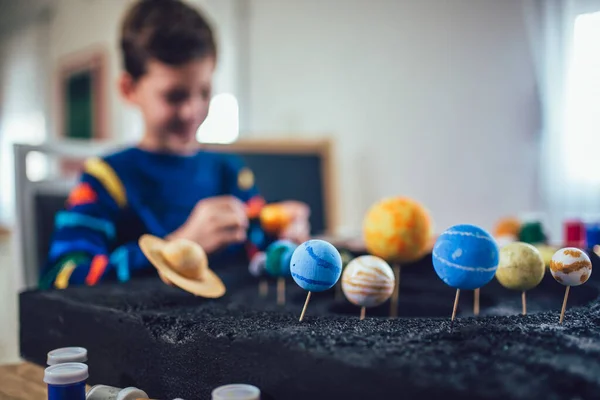 快乐的男生为家里的一个学校科学项目造了一个太阳系 — 图库照片
