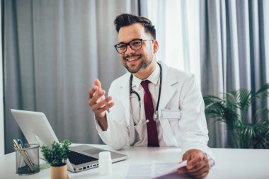 Ofiste bilgisayarla çalışan genç doktor.