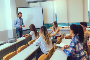 Proffesor, üniversite atölyesindeki konferans salonunda sunum yapıyor..