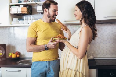 Hamile kadın kocasıyla mutfakta eğleniyor..