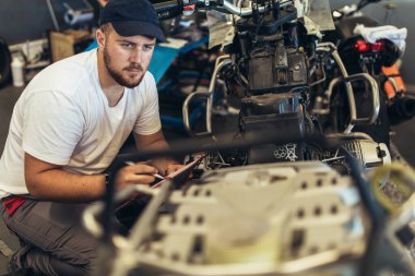 Motosiklet tamir servisinde çalışan profesyonel bir motor tamircisi.
