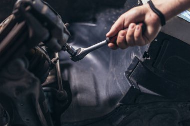 Teknisyen tamirhanede kontrol ve servis arabası üzerinde çalışıyor.