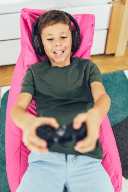 Evinde video oyunu oynayan küçük çocuk.
