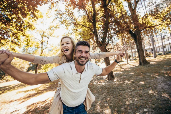 Novio Llevando Novia Cuestas Parque Otoño — Foto de Stock