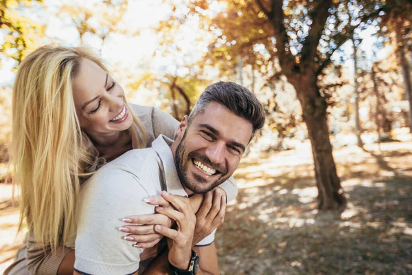 Pojkvännen Bär Sin Flickvän Piggyback Höstparken — Stockfoto