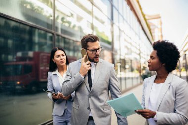 Bir grup iş adamı dışarıda toplanıyor. Patronla çalışıyor..