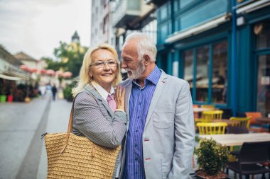 Olgun evli bir çift şehirde birlikte yürüyor..