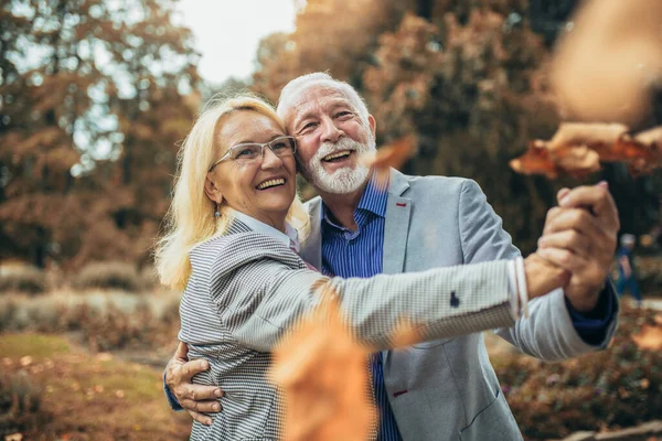 快乐的老夫妇在秋天的公园 — 图库照片