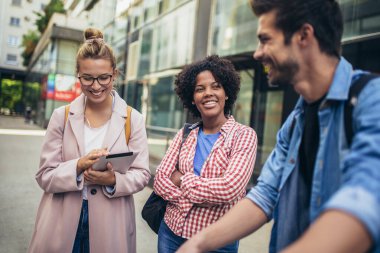 Üniversite öğrencileri kampüste açık havada okuyor.