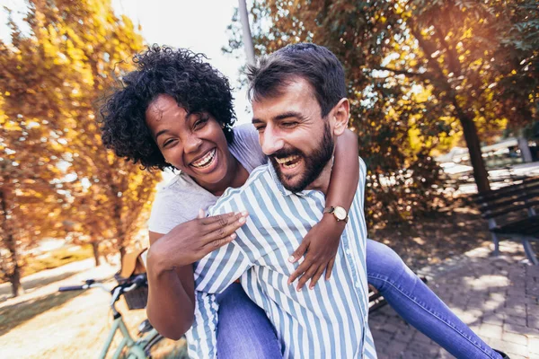 Casal Jovem Divertindo Parque Dia Outono Bonito Homem Dando Porquinho — Fotografia de Stock