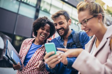 Üniversite öğrencileri okul kampüsünde telefon kullanarak eğitim görüyorlar..