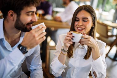 Samimi bir kafede kahve içen bir çift. Sıcak, rahat atmosfer, samimi sohbet ve neşeli sosyal anlar..