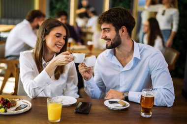 Samimi bir kafede kahve içen bir çift. Sıcak, rahat atmosfer, samimi sohbet ve neşeli sosyal anlar..