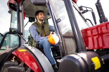 Kamyon kabininde oturan genç profesyonel kamyon şoförü, yoldaki aracı kullanmaya ve çalıştırmaya hazır..