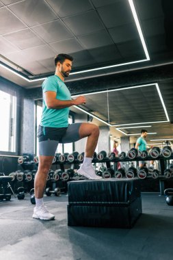 Spor salonunda güçlü bir adam kutuya adım atar, güç, spor ve spor üzerine yoğunlaşır..