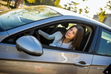 Genç bir kız, araba kullanırken neşe dolu gülüşü, özgürlüğün ve maceranın özünü yakalıyor..