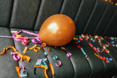 Konfeti, pasta ve hediyelerle kaplı dağınık masa ve kanepe. Yeni yıl, doğum günü ve kutlama partisinden kaotik bir sabah sahnesi..