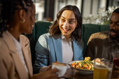 Çeşitli iş adamları bir kafede gündelik bir toplantı yapıyor, fikirleri tartışıyor, işbirliği yapıyor ve rahat bir ortamda bağlantılar kuruyor..