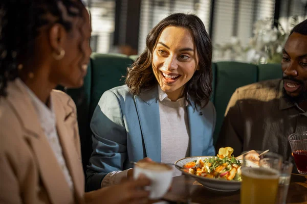 Çeşitli iş adamları bir kafede gündelik bir toplantı yapıyor, fikirleri tartışıyor, işbirliği yapıyor ve rahat bir ortamda bağlantılar kuruyor..