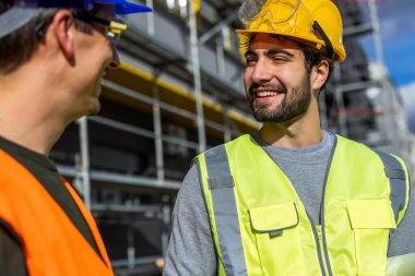 İnşaat alanında güvenlik ekipmanı mühendisleri konuşuyor.