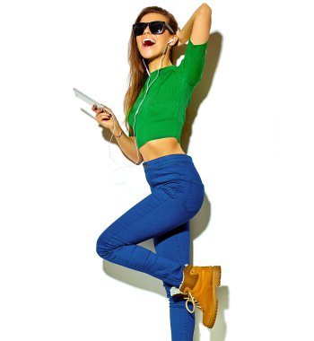 Beyaz smartphone kulaklık ile müzik dinleme güneş gözlüklü esmer kadın kız rahat yeşil hipster yaz giysileri hiç makyaj ile gülümseyen güzel deli portresi izole