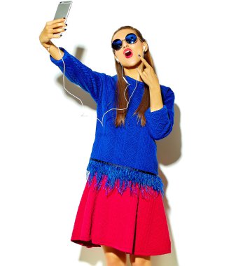 güzel mutlu sevimli gülümseyen seksi esmer kadın rahat yaz renkli giysileri kızı kırmızı dudaklar ile smartphone ve gösteren kaya beyaz yapma selfie fotoğrafa bir rulo işareti izole