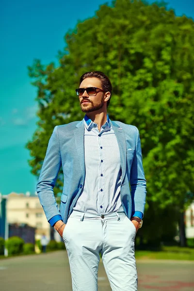 High fashion look.Young stylish confident happy handsome  businessman model man in blue suit cloth lifestyle in the street in sunglasses — Stock Photo, Image