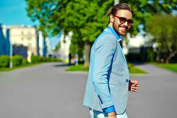 High fashion look.Young stylish confident happy handsome  businessman model man in blue suit cloth lifestyle in the street behind sky in sunglasses — Stock Photo, Image