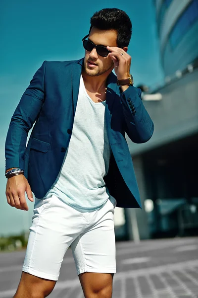 Υψηλή μόδα βλέμμα. Άνθρωπος μοντέλο νέο κομψό αυτοπεποίθηση ευτυχισμένη όμορφος επιχειρηματία στο μπλε κοστούμι ύφασμα τρόπο ζωής στο δρόμο στην γυαλιά ηλίου πίσω από τον ουρανό — Φωτογραφία Αρχείου