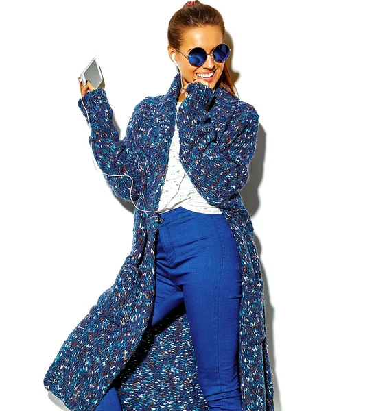Porträt der schönen fröhlich lächelnde brünette Frau Mädchen in lässiger blauer Hipster-Sommerkleidung ohne Make-up isoliert auf weiß in Sonnenbrille Musik hören in Smartphone mit Kopfhörern — Stockfoto