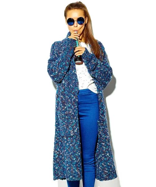 Portret van mooie gelukkig leuke brunette vrouw meisje in casual blauwe hipster zomer kleding zonder make-up geïsoleerd op wit in zonnebril drinken cola uit de fles met rietje — Stockfoto