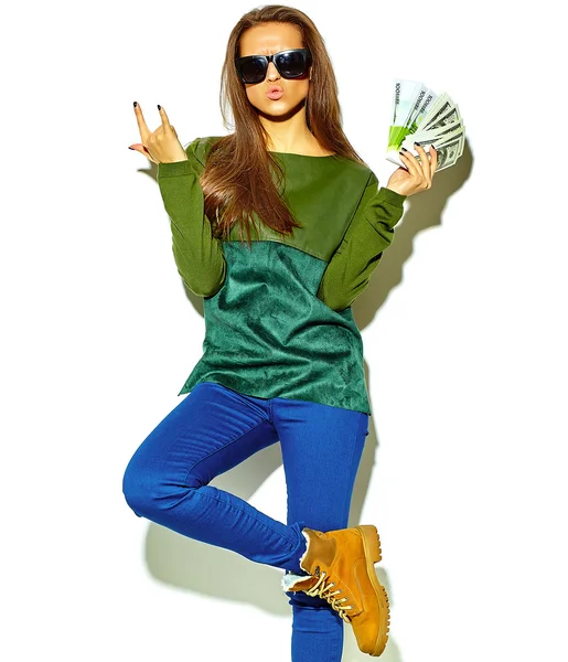 Bella felice carino sorridente bruna donna ragazza in casual verde hipster vestiti estivi senza trucco isolato su bianco in occhiali da sole in possesso di dollari e banconote in euro, mostrando segno rock and roll — Foto Stock