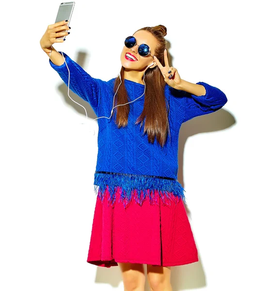 Hermosa feliz linda sonriente sexy morena chica en verano casual ropa colorida con labios rojos aislados en blanco haciendo foto selfie en el teléfono inteligente y mostrando signo de paz — Foto de Stock