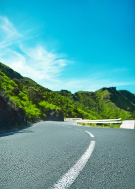 Beyaz hat yolu ile mavi gökyüzü ve boş kırsal asfalt perspektif ile dönüm dağ karayolu 