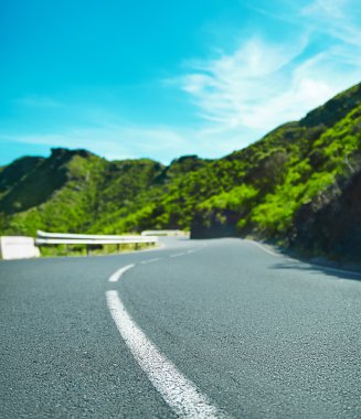 Beyaz hat yolu ile mavi gökyüzü ve boş kırsal asfalt perspektif ile dönüm dağ karayolu 