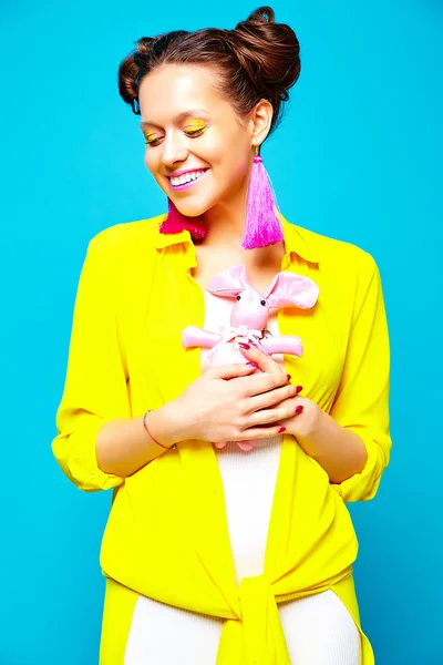 Portrait of cheerful fashion hipster girl in casual colorful vivid hipster yellow summer clothes on blue background — Stock Photo, Image