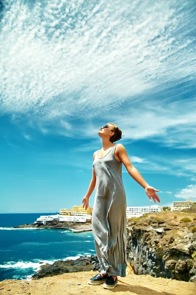Šťastná dívka stylové žena v neformální hipster oblečení, stojící na útesu hory s zvedl ruce ke slunci a slaví úspěch — Stock fotografie