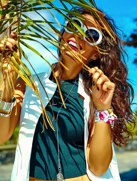 Moda elegante bonito jovem sorrindo morena mulher modelo no verão hipster roupas casuais posando perto de palmeira árvore folha — Fotografia de Stock