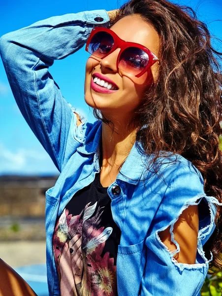 Mode stijlvolle mooie jonge lachende brunette vrouw model in zomer hipster Bright kleurrijke casual blauwe kleren poseren in de straat — Stockfoto